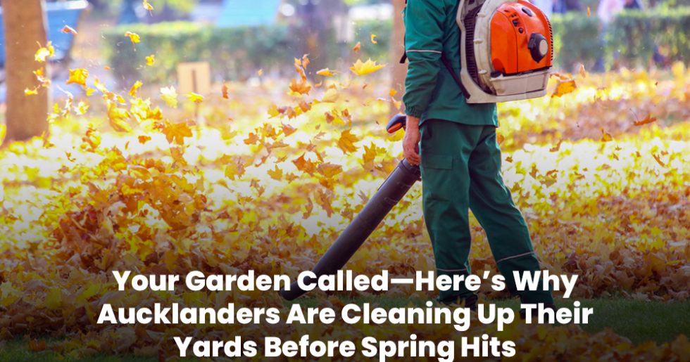 Professional using a leaf blower to clear autumn leaves in an Auckland backyard.