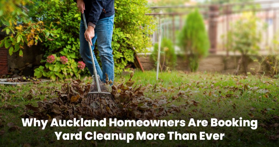 Man raking fallen leaves in a backyard in Auckland, representing rising demand for yard cleanup services.