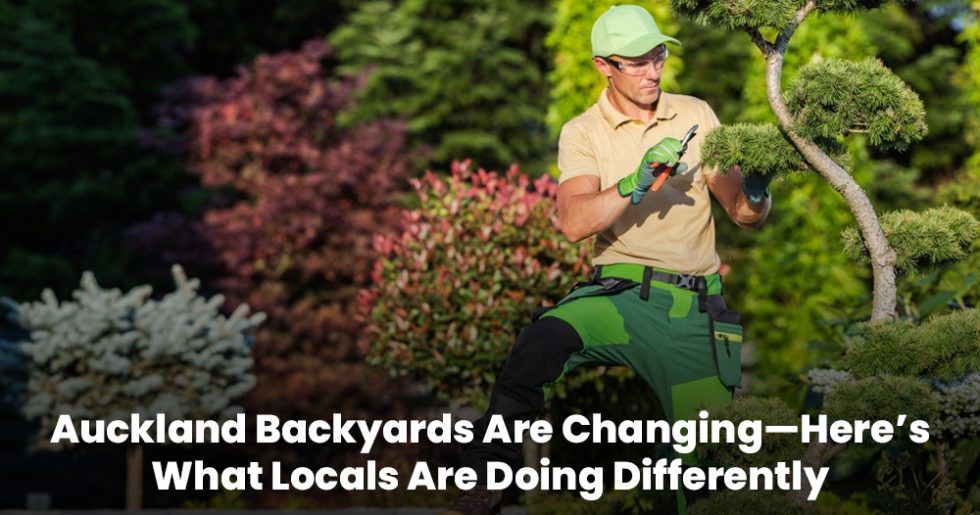 Professional landscaper trimming a tree in a colourful Auckland backyard.