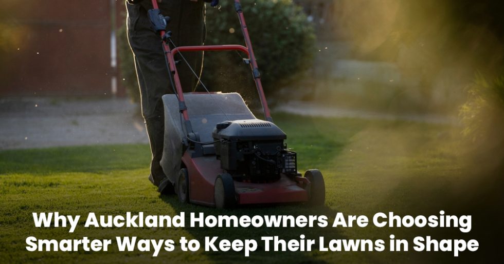 Close-up of a person mowing the lawn with a red push mower in Auckland backyard
