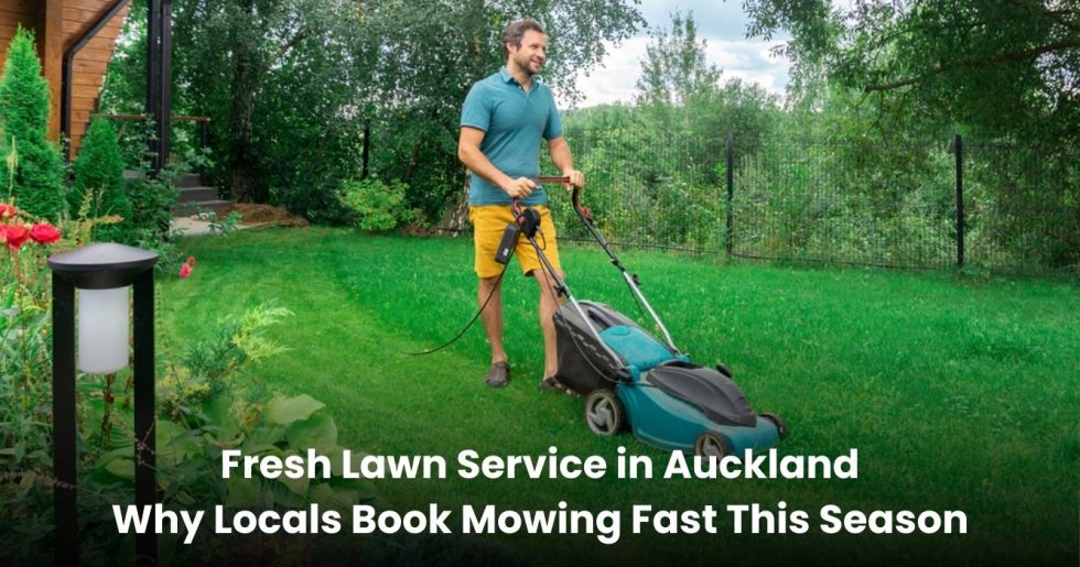 Man mowing a green backyard lawn with a push mower in Auckland during summer lawn care service.